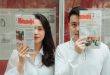 close up shot of a couple holding newspapers